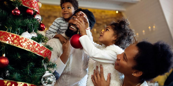 familia adornando árbol navidad